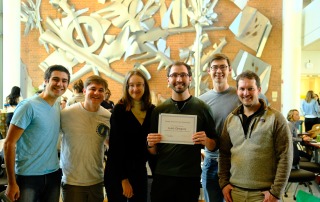 Group photo of the Walker lab in front of a brick building