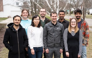 Group photo of the lab in front of a house